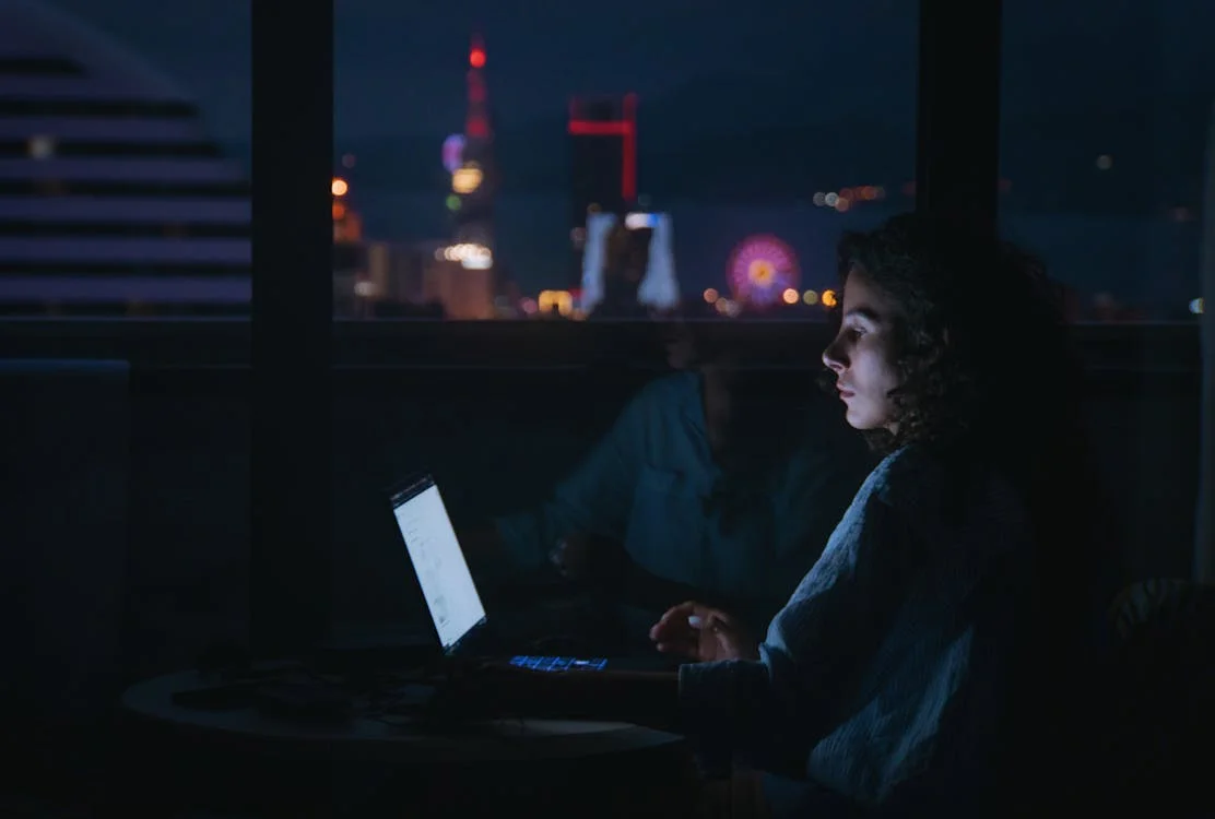 Personne concentrée sur son laptop dans une pièce sombre — l'hyperfocus TDAH, absorption totale sans notion du temps