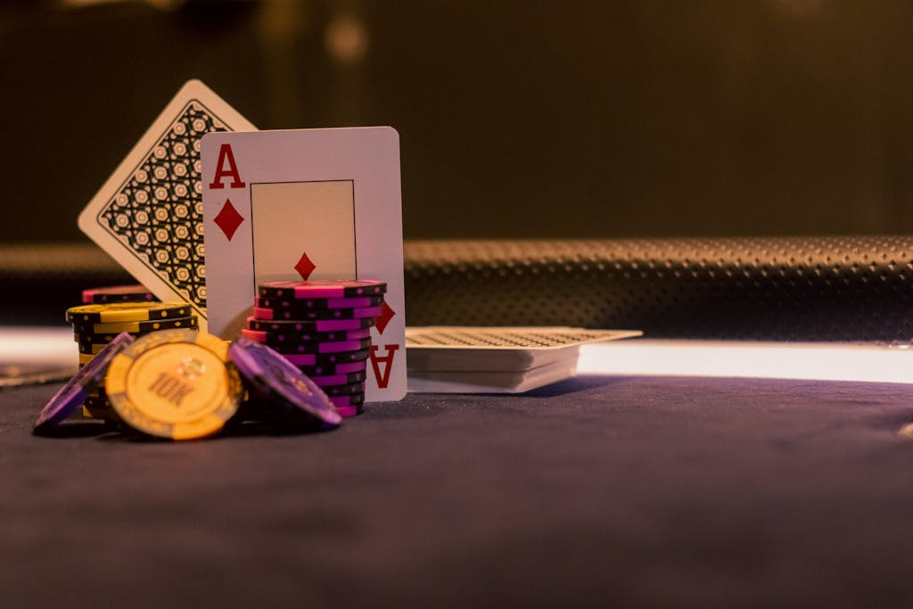 Jetons de poker et as de carreau sur une table de casino dans une ambiance tamisée