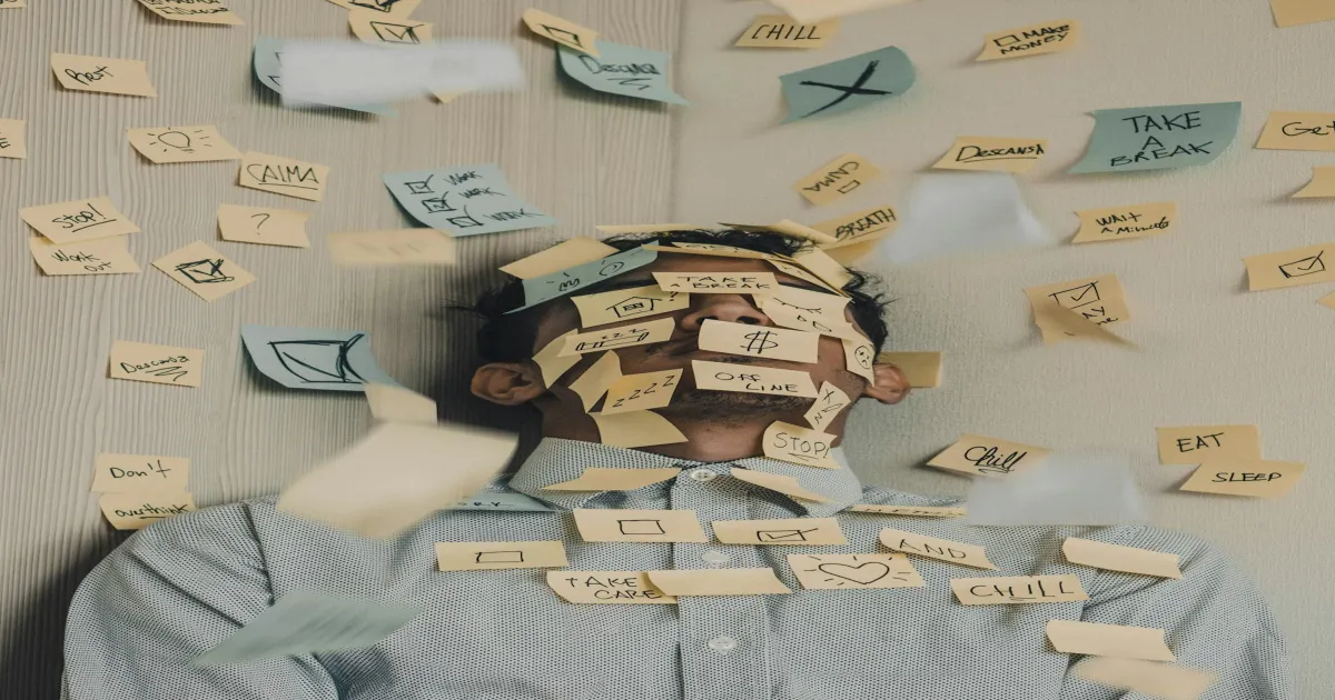 Personne couverte de post-its colles sur le visage et le corps, symbolisant le chaos mental et la surcharge cognitive du TDAH